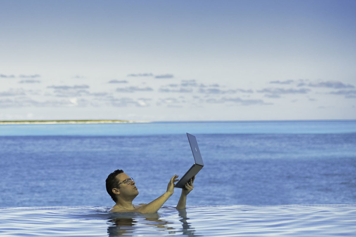 Monday motivation - Tim Sykes swims with laptop exemplifying mindset mastery to achieve success